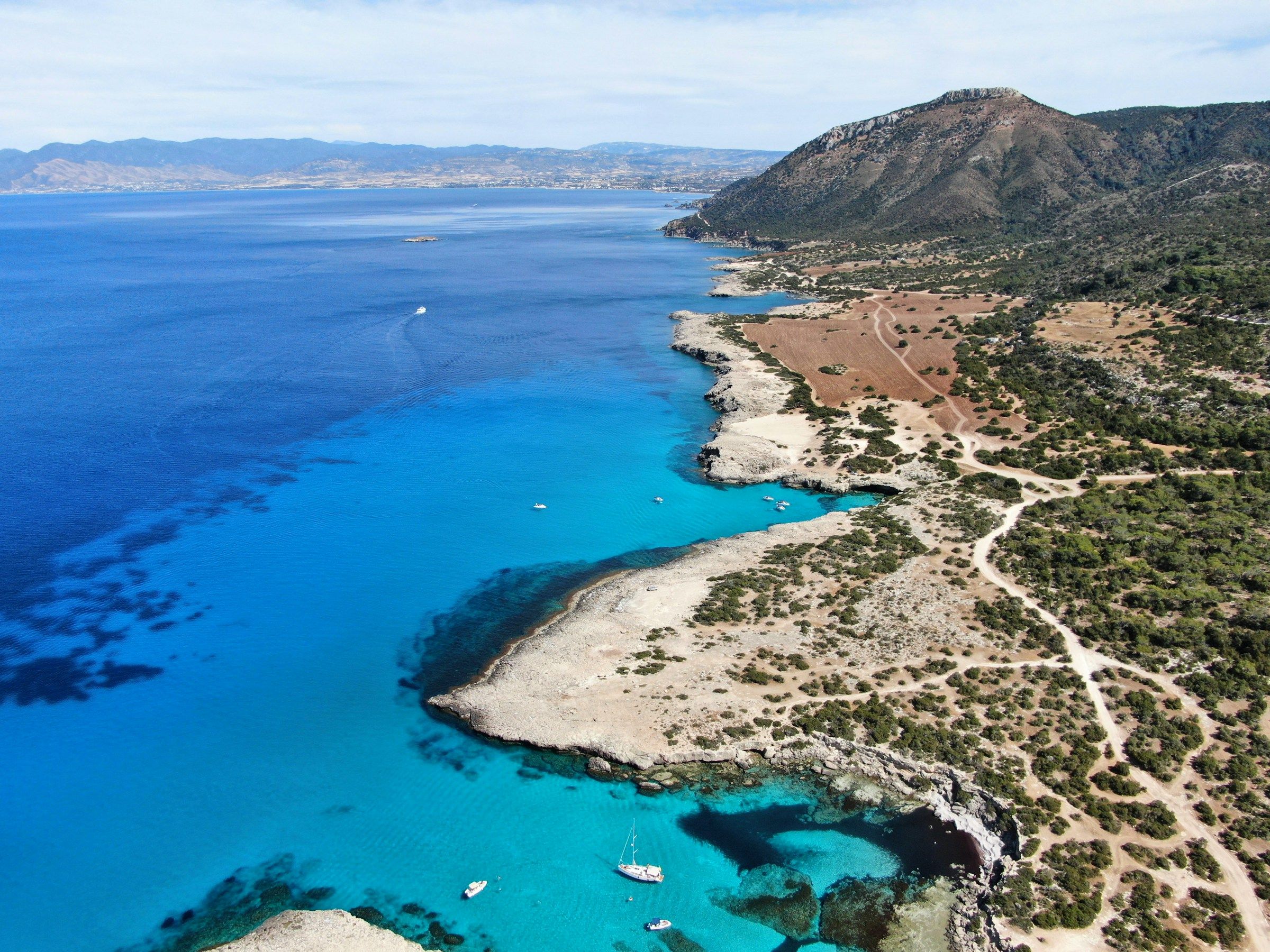 The Paphos coastline from above, with clear blue water along a rocky shore.